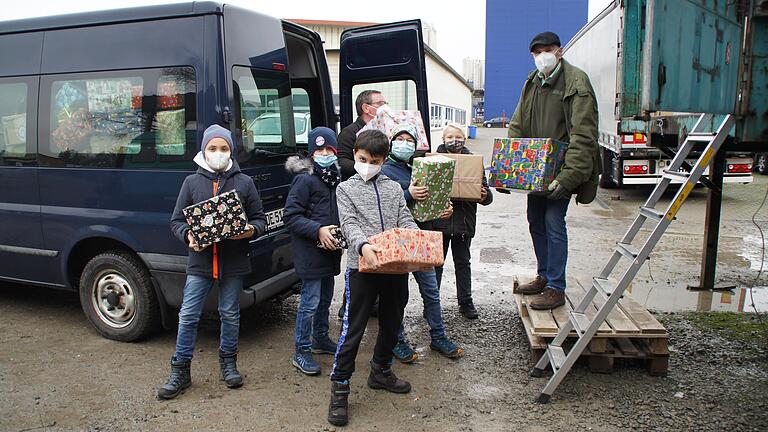 Schüler der 4a und 4b helfen zusammen mit Herrn Karlheinz Bielek und Herrn Ottmar Deppisch  beim Verladen der Weihnachtspäckchen.