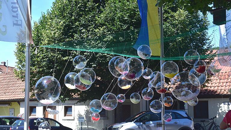 Eine Luftballoninstallation der Urainerin Klimshin am Dorfplatz zeigt die Zerbrechlichkeit unserer heutigen Welt.       -  Eine Luftballoninstallation der Urainerin Klimshin am Dorfplatz zeigt die Zerbrechlichkeit unserer heutigen Welt.