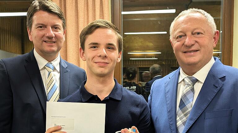 DLRG-Rettungsschwimmer Jan Wehler - DLRG-Rettungsschwimmer Jan Wehler (21; Mitte) aus Nüdlingen wurde von Staatssekretär Sandro Kirchner (links) und Landrat Thomas Bold mit der Fluthelfernadel ausgezeichnet. DLRG-Rettungsschwimmer Jan Wehler - DLRG-Rettungsschwimmer Jan Wehler (21; Mitte) aus Nüdlingen wurde von Staatssekretär Sandro Kirchner (links) und Landrat Thomas Bold mit der Fluthelfernadel ausgezeichnet.