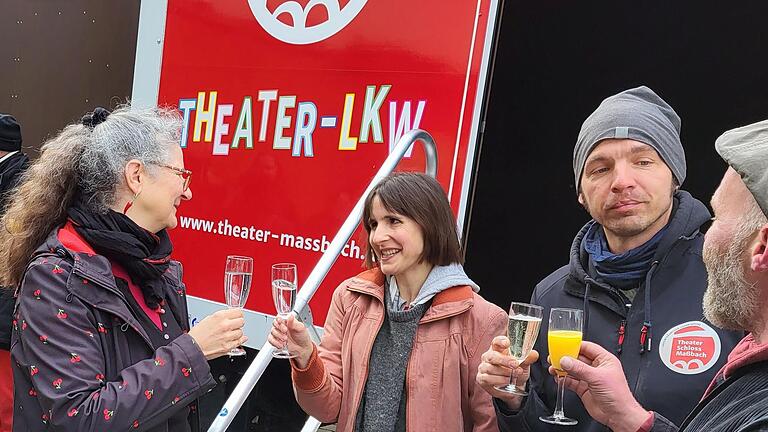 Das Theater Maßbach spielt  jetzt auch im Lastwagen. Theaterchefin Anne Maar (links) und Schauspielerin Erika Mosonyi stoßen auf die gelungene Premiere im neuen Theater-Lkw an, ebenso Mitarbeiter des technischen Teams.       -  Das Theater Maßbach spielt  jetzt auch im Lastwagen. Theaterchefin Anne Maar (links) und Schauspielerin Erika Mosonyi stoßen auf die gelungene Premiere im neuen Theater-Lkw an, ebenso Mitarbeiter des technischen Teams.