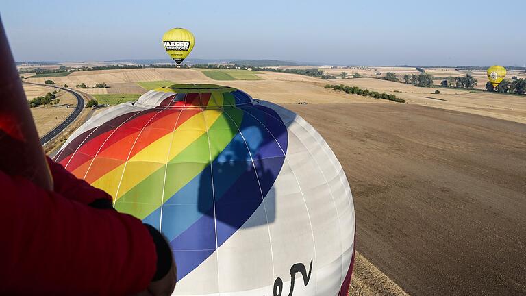 In Reih und Glied: Mehrere Ballons fahren über die abgeernteten Felder des Grabfelds.