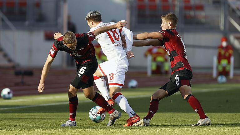 Leichte Verwirrung beim 1. FC Nürnberg: Düsseldorfs Thomas Pledl (Mitte) , früher auch mal in Fürth, geht mit dem Ball zwischen Tim Handwerker (links) und Fabian Nürnberger hindurch.