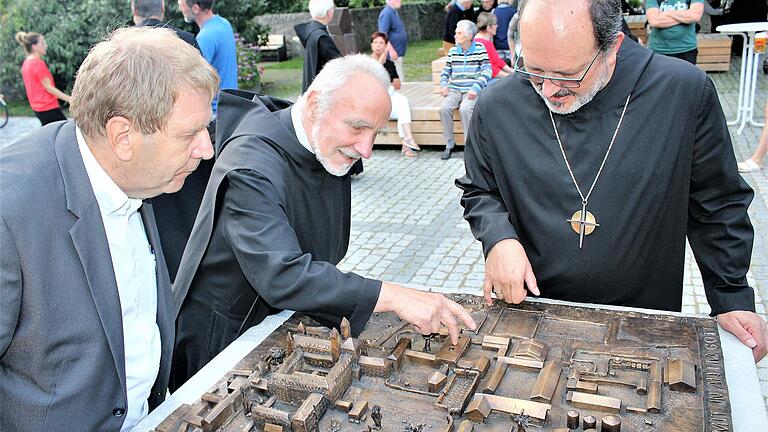 Ein gegossenes Modell der gesamten Klosteranlage ziert nun den Vorplatz zur Abteikirche in Münsterschwarzach. Pater Meinrad Dufner (Mitte) hat es gefertigt und erklärt Abt Michael Reepen (rechts) und Jürgen Eisentraut vom Amt für Ländliche Entwicklung die Details. Ein gegossenes Modell der gesamten Klosteranlage ziert nun den Vorplatz zur Abteikirche in Münsterschwarzach. Pater Meinrad Dufner (Mitte) hat es gefertigt und erklärt Abt Michael Reepen (rechts) und Jürgen Eisentraut vom Amt für Ländliche Entwicklung die Details.