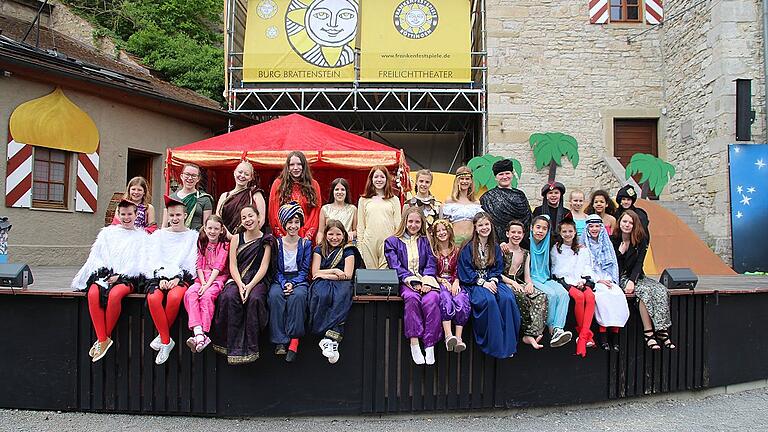 Farbenfroh, glitzrig-funkelnd und gut gelaunt: das &bdquo;Kalif Storch&ldquo;-Ensemble der Realschule Ochsenfurt bei der ersten Bühnenprobe vor der Musical-Premiere auf Burg Brattenstein.