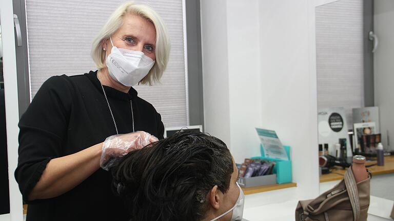 Susanne Feser frisiert in ihrem Friseursalon 'Salon Eva' in Gerolzhofen einer Kundin die Haare.