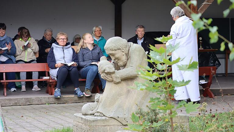 Gottesdienstbeauftragte Elke Dressel erinnert in der Wortgottesfeier, die immer am Beginn des Franziskus-Festet steht an die Liebe des Patrons des Hauses Franziskus zur Schöpfung Gottes. Nach wie vor ist die Botschaft seines Sonnengesanges aktuell, dass wir Menschen auch Teil dieser Schöpfung sind, verantwortlich für ihren Schutz. Im Vordergrund die Statue des Schutzpatrons des Hauses Franziskus, - in Augenhöhe für die Kinder des Kindergartens St. Franziskus, der bis 2009 bestand.