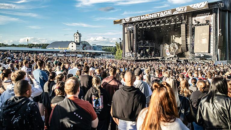 In die Autobahnkirche im Hintergrund und vorne Tausende Menschen, die das Heroes Festival in Geiselwind besuchten.