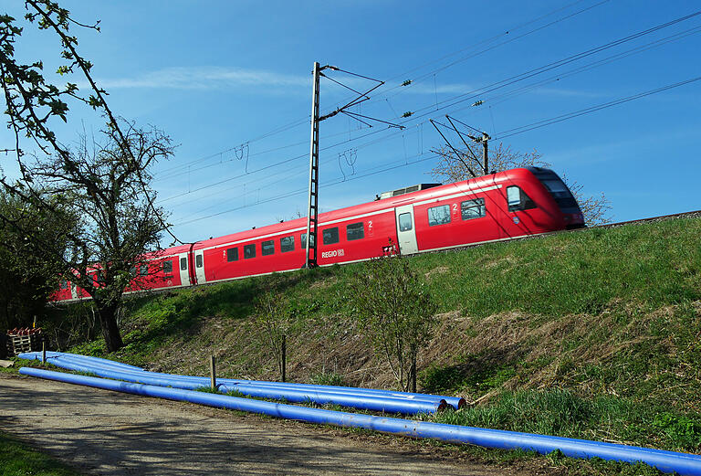 Die blauen Rohre für das Fernwasser liegen schon für das Durchschießen unter dem Bahndamm bereit. Der Dorfbereich wird über die Bergtheimer Frühlingstraße angeschlossen.