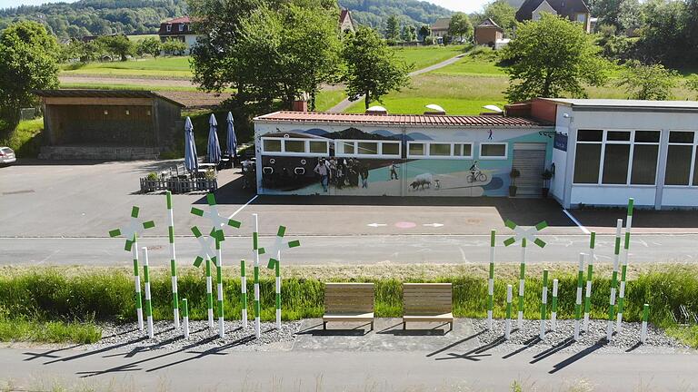 Einer der Rastpunkte entlang des Rhönexpress Bahn-Radwegs mit Installation, Mobiliar und Fassadengestaltung.       -  Einer der Rastpunkte entlang des Rhönexpress Bahn-Radwegs mit Installation, Mobiliar und Fassadengestaltung.