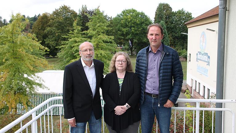 In Sorge wegen des Projekts vor ihrer Haustüre: (von links) Stefan Ehrl, Monika Stamm und Thomas Grön auf dem Balkon der Familie Ehrl. Im Hintergrund das mit Bäumen bestandene Areal, auf dem die Erweiterung des Mehrgenerationenspielplatzes geplant ist.