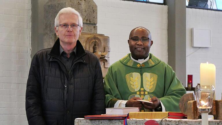 Father Dunstan Asiimwe freut sich über die Spende der KAB Erbshausen-Sulzwiesen, die ihm Heinz Zimmermann vom Vorstandsteam im Sonntagsgottesdienst übergeben hat.