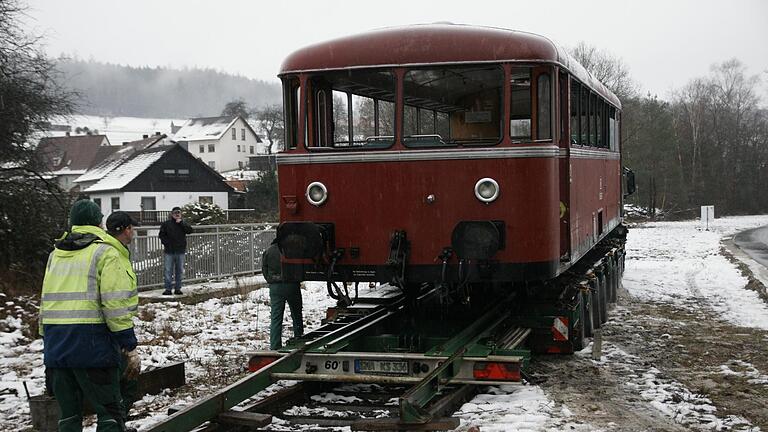 Sanft wird der Schienenbus vom Tieflader auf die von der Sinntalbahn verbliebenen Gleise gelassen. Er soll die frühere Nutzung zeigen und den Radweg aufwerten.  Foto: Steffen Standke       -  Sanft wird der Schienenbus vom Tieflader auf die von der Sinntalbahn verbliebenen Gleise gelassen. Er soll die frühere Nutzung zeigen und den Radweg aufwerten.  Foto: Steffen Standke