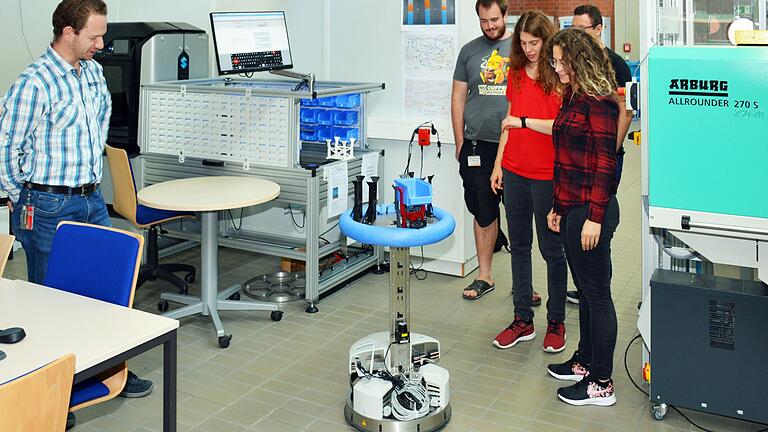 Studierende arbeiten in der c-factory mit einem autonomen Roboter.