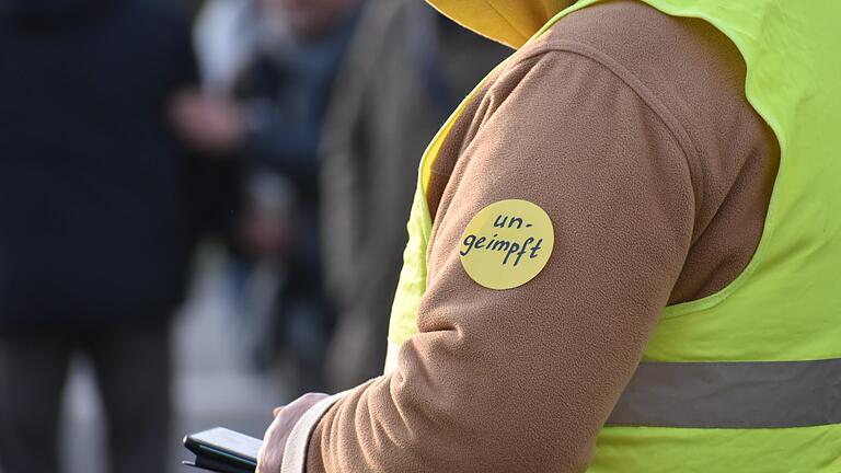 Angeheftete Markierungen im Stil des 'Gelben Sterns' auf 'Querdenker'- Demos in Würzburg vergleichen Impfungen mit der Verfolgung der Jüdinnen und Juden während der NS-Zeit in Deutschland.