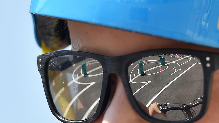 Ein Junge trägt eine Sonnenbrille auf einem Fahrrad-Parcours       -  Sonnenschutz für Kinderaugen ist unerlässlich: Sonnenbrille und Sonnencreme sollten ständige Begleiter sein.