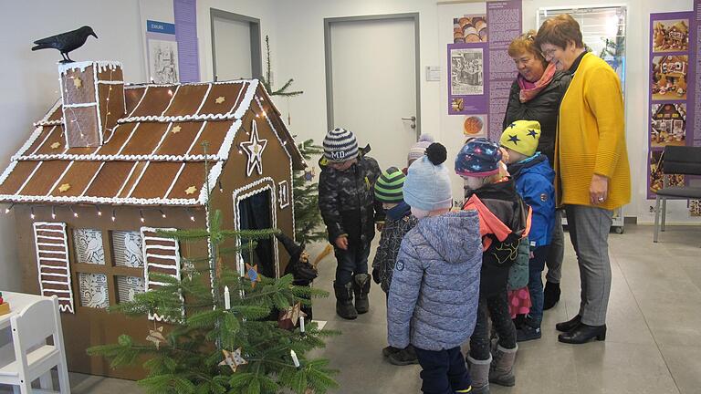 Voller Bewunderung stehen Kinder des Hergolshäuser Kindergartens mit ihrer Betreuerin Maria Theiss und Wernecks Bürgermeisterin Edeltraud Baumgartl (rechts) vor dem großen Lebkuchenhaus im Rathausfoyer.