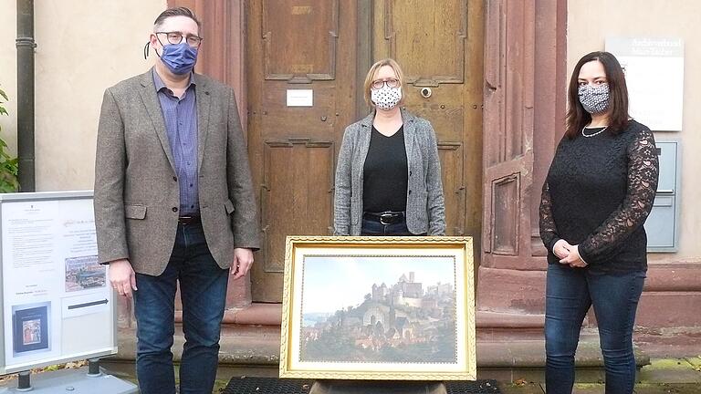 Das Ölgemälde, das eine Ansicht der Stadt von Westen zeigt, fand den Weg in das Grafschaftsmuseum. Im Bild Dr. Frank Kleinhagenbrock, Vorsitzender des Historischen Vereins Wertheim, Stefanie Arz , Leiterin des Grafschaftsmuseums, und Bettina Winkler, Leiterin der Geschäftsstelle des Historischen Vereins Wertheim, bei der Übergabe des Wertheim-Gemäldes vor dem Archivverbund Main-Tauber im Kloster Bronnbach.