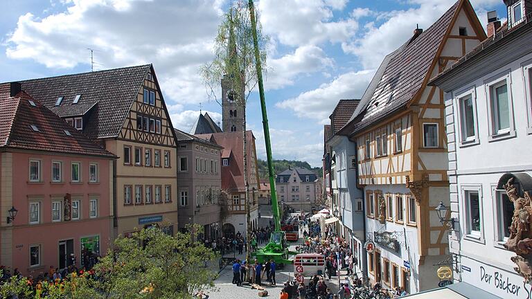 Mit schwerem Gerät und unter großem Zuschauerinteresse wird der traditionelle Maibaum aufgestellt (Archivbild).