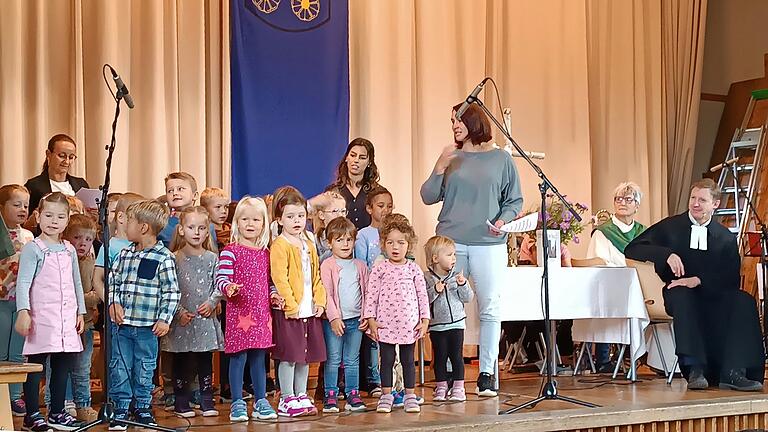 Die Kinder aus dem Kindergarten „Arche Noah“, der beim Dorfgemeinschaftsfest offiziell eröffnet wurde, gestalten den ökumenischen Gottesdienst mit Liedeinlagen und Vorträgen mit. Rechts der evangelische Pfarrer Oliver C. Habiger und die kath Gemeindereferentin Birgit Kuhn.