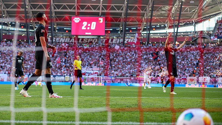 RB Leipzig - FC Augsburg.jpeg       -  Und wieder schlägt der Ball im Augsburger Tor ein. Niklas Dorsch, Maximilian Bauer und Elvis Rexhbecaj (von links) nach dem 3:0 durch Leipzigs David Raum.