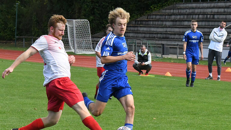 Die Spiele der A-Klassen Rhön       -  Den Vormarsch von Adrian Kiesel von der SG Großwenkheim/Münnerstadt II (rechts) bremst Hausens Mario Simon mit seinem ausgefahrenen Bein.