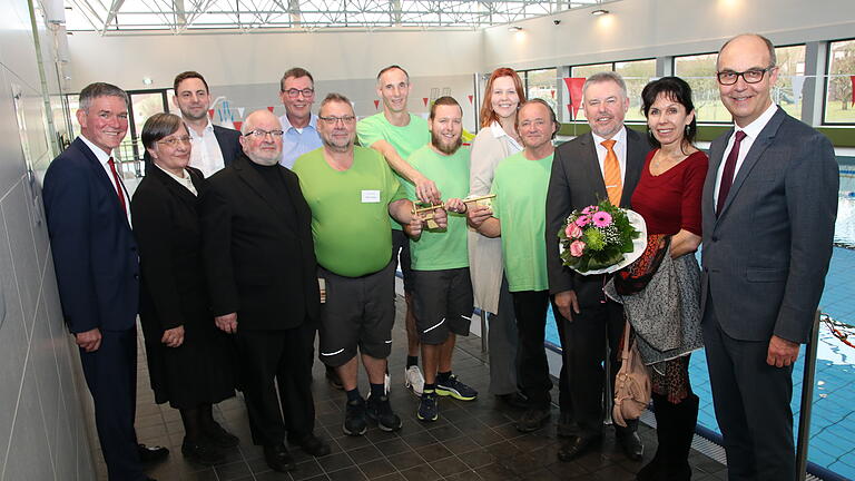 Im nagelneuen Hallenbad stellten sich die Hauptpersonen der Einweihungsfeier dem Pressefotografen (von links): Bürgermeister Peter Kornell, Pfarrerin Christiane Rüpplein, Simon Wenger (Projektsteuerung), Pfarrer Johannes Hofmann, Bauhofleiter Harald Troll, das Bademeisterteam mit Betriebsleiterin Nicole Mokros (Neunte von links), stellvertretender Landrat Paul Streng (ab Dritter von rechts), Bauamtschefin Ulla Gistel-Gareis und Regierungsvizepräsident Jochen Lange.