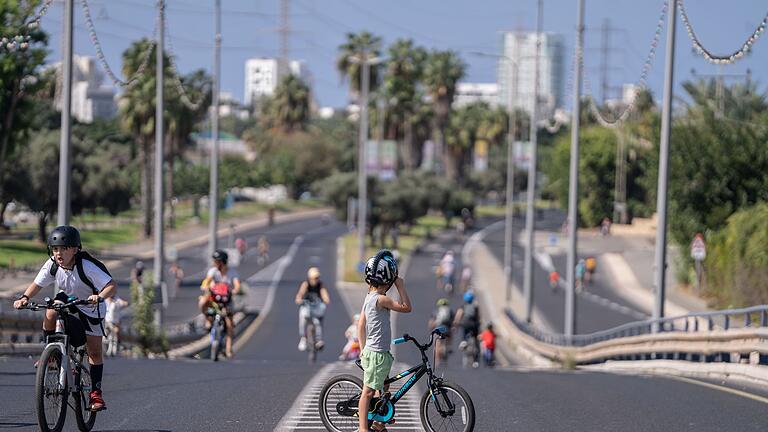 Jom Kippur in Israel       -  Menschen in Israel sind mit ihren Fahrrädern auf einer leeren Straße am Feiertag Jom Kippur unterwegs (Foto aktuell).