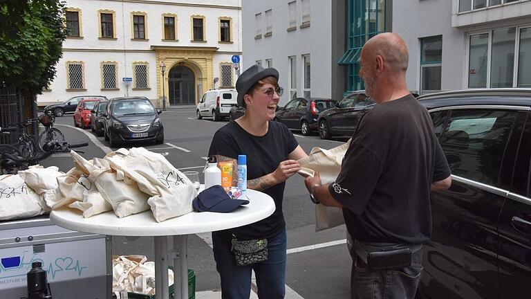 Stefanie Behnecke (links) verteilt die Hitzebeutel an wohnungs- und obdachlose Menschen in der Stadt Würzburg.