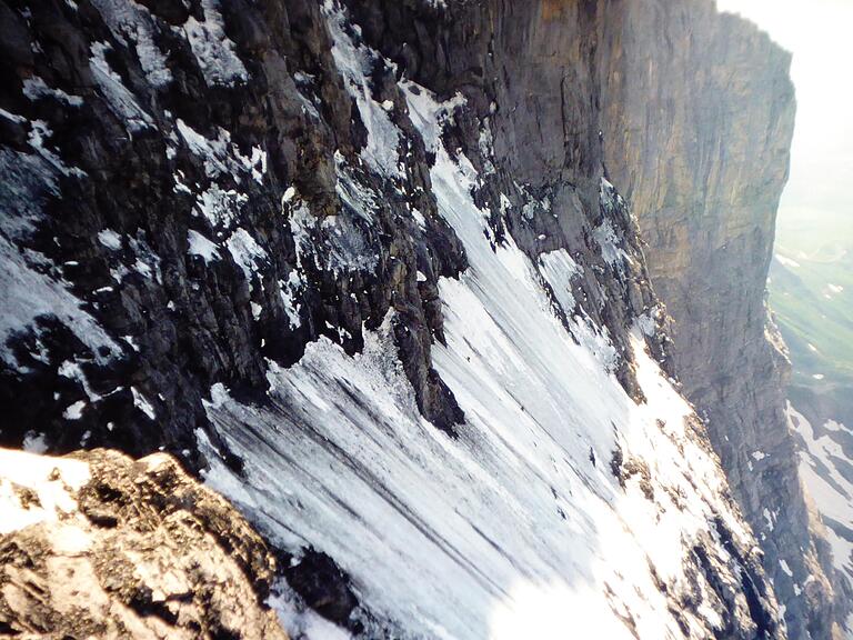 Ein Eisfeld in der Eiger-Nordwand mit zwei Bergsteigern, die als winzige Pünktchen erscheinen.&nbsp;