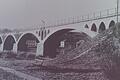 4.4.1945: Sprengung der Kitzinger Mainbrücken durch deutsche Pinoniere. Die in Bruchstein gemauerte einspurige Gerolzhöfer Eisenbahnbrücke prägte mit ihren gotisch anmutenden Bogen die Landschaft am Main. Das Bild entstand in den 1920er-Jahren. Rudolf Joachim