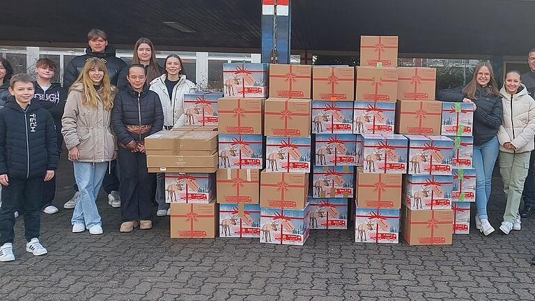 SchülerInnen des BNG helfen Alexander Thauer und Esteban Rincon Roth beim Verladen der Pakete.