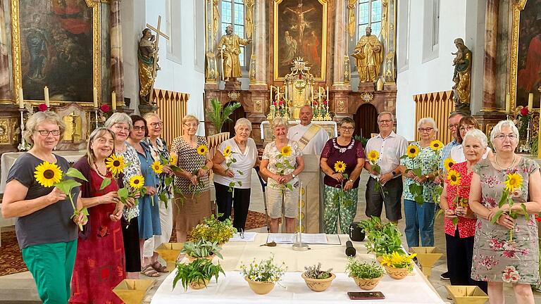 Um den Altar von „Heilig Kreuz“ die Mitwirkenden beim Kräuter-Gottesdienst von „Generation Plus“ und „Zeit für einander Schwarzach“ zusammen mit Katrin Anger von der Gemeindecaritas und Diakon Lorenz Kleinschnitz mit den von ihm überreichten „Wertschätzungs–Sonnenblumen“.