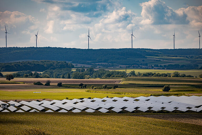 Erneuerbare Energien:&nbsp; Im Hintergrund der Windpark bei Sailershausen, im Vordergrund ein Solarpark bei Königsberg. Der Windpark könnte den Strom für die Anlage liefern.