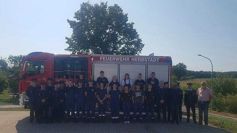 Alle Beteiligten nach bestandener Prüfung vor dem neuen Feuerwehrauto der Feuerwehr Herbstadt.