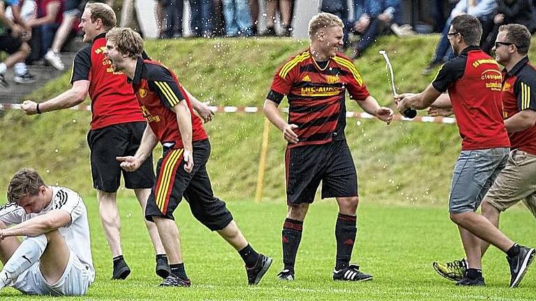 Des einen Freud, des anderen Leid: Die SG Heustreu/Hollstadt feiert den Aufstieg in die Kreisliga Rhön, Julian Bocklet (SG Windshausen/Brendlorenzen) sitzt frustriert am Boden.