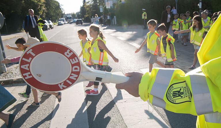 Kinder mit Warnwesten laufen während der Aktion 'Sicher zur Schule' über einen Zebrastreifen, der von einem Schülerlotsen gesichert ist. Die Polizeiinspektion Lohr gibt Eltern Tipps für einen sicheren Schulweg. Kinder mit Warnwesten laufen während der Aktion 'Sicher zur Schule' über einen Zebrastreifen, der von einem Schülerlotsen gesichert ist. Die Polizeiinspektion Lohr gibt Eltern Tipps für einen sicheren Schulweg.