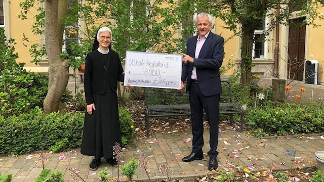 Schwester Katharina Merz, Leiterin der St.-Ursula-Schule und Ekkehard Schippers, Präsident des Rotary Club Würzburg-Residenz bei der Übergabe des symbolischen Spenden-Schecks über 6000 Euro.