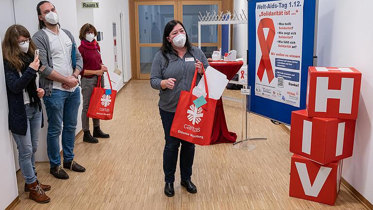 Heidrun Brand, Leiterin der Caritas-Aids-Beratung Unterfranken, verteilt Aktionstaschen an die teilnehmenden Organisationen und Gruppen im Bündnis „Würzburg zeigt Schleife“. Heidrun Brand, Leiterin der Caritas-Aids-Beratung Unterfranken, verteilt Aktionstaschen an die teilnehmenden Organisationen und Gruppen im Bündnis „Würzburg zeigt Schleife“.