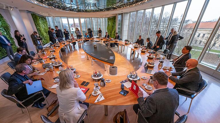 Sitzung bayerisches Kabinetts       -  Die Minister und der Ministerpräsident sitzen zu Beginn der Sitzung des bayerischen Kabinetts gemeinsam am Tisch.