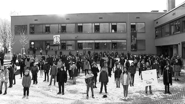 Großer Chor auf dem Pausenhof: 250 Schülerinnen und Schüler der Udo-Lindenberg-Mittelschule Mellrichstadt sangen gemeinsam das Lied 'Wozu sind Kriege da?' von Udo Lindenberg aus dem Jahr 1981.