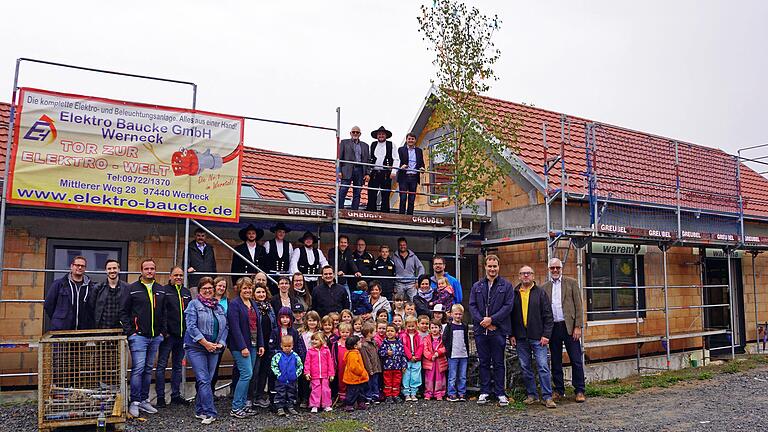 Ein von den Kindergartenkindern geschmücktes Bäumchen und eine fröhliche Festgemeinschaft gab es beim Richtfest für den neuen Kindergarten in Hausen. Auf dem Gerüst hatten Norbert Wendel vom Trägerverein St. Elisabeth, Zimmerermeister Christoph Arnold und Bürgermeister Bernd Schraud (von links) beim Richtspruch auf das Wohl des Bauherrn, der Bauleiter und Handwerker angestoßen.