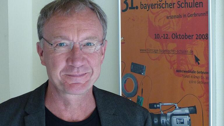 Thomas Schulz, der Leiter der Schulfilmtage Bayerischer Schulen vor dem Plakat der ersten Schulfilmtage in Gerbrunn. Foto: Traudl Baumeister