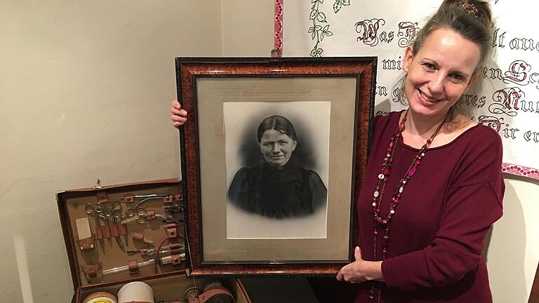 Simone Michel-von Dungern, Leiterin des Museums Malerwinkelhaus in Marktbreit. Sie hält das Foto ihrer Urgroßmutter, die Hebamme in Seinsheim war. Auf dem Tisch steht der Hebammenkoffer ihrer Großtante. Die Objekte sind in der ständigen Ausstellung 'Frauenzimmer' zu sehen. Simone Michel-von Dungern, Leiterin des Museums Malerwinkelhaus in Marktbreit. Sie hält das Foto ihrer Urgroßmutter, die Hebamme in Seinsheim war. Auf dem Tisch steht der Hebammenkoffer ihrer Großtante. Die Objekte sind in der ständigen Ausstellung 'Frauenzimmer' zu sehen.