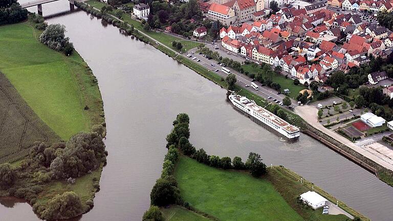 Haßfurt Hafen       -  Die Umbauten im und am Main werden in Haßfurt gravierend ausfallen. Die halbkreisförmige Mole an der Westseite des Hafens muss weichen, zwischen Mainbrücke und Tränkberg wird eine Schiffsanlegestelle für ruhebedürftige Kapitäne von Schubverbänden eingerichtet, die Anlegestelle für Passagierdampfer kommt in den Hafen, die Mainbrücke wird durch eine neue ersetzt und zuletzt steht die Uferpromenade zur Renovierung an.