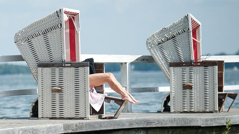 Eine Frau sitzt in einem Strandkorb - Nackt die Sonne genießen? Gute Idee! Dann aber bitte auch an den Sonnenschutz für den Intimbereich denken. Eine Frau sitzt in einem Strandkorb - Nackt die Sonne genießen? Gute Idee! Dann aber bitte auch an den Sonnenschutz für den Intimbereich denken.
