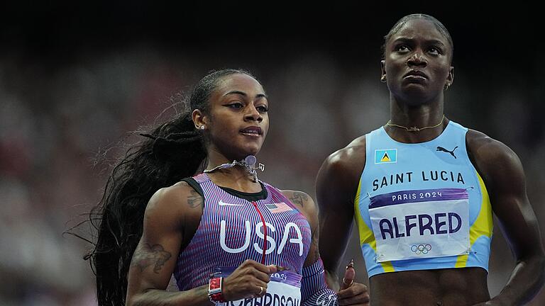 Paris 2024 - Leichtathletik       -  Julien Alfred (r) holte überlegen Gold über die 100 Meter