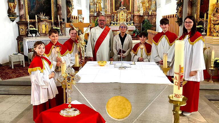 Vor dem Altar in der Pfarrkirche Stadtschwarzach der Kreuzpartikel, dahinter Diakon Lorenz Kleinschnitz und Gemeindereferentin Ilse Waldenmeier, die den Ministranten die Kreuze aus der Jerusalemer Grabeskirche überreichte. Vor dem Altar in der Pfarrkirche Stadtschwarzach der Kreuzpartikel, dahinter Diakon Lorenz Kleinschnitz und Gemeindereferentin Ilse Waldenmeier, die den Ministranten die Kreuze aus der Jerusalemer Grabeskirche überreichte.