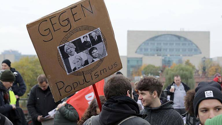 Archivbild: Ein Plakat mit dem Slogan 'Gegen Populismus' ist im November 2016 auf einer Kundgebung vor dem Bundeskanzleramt in Berlin zu sehen.