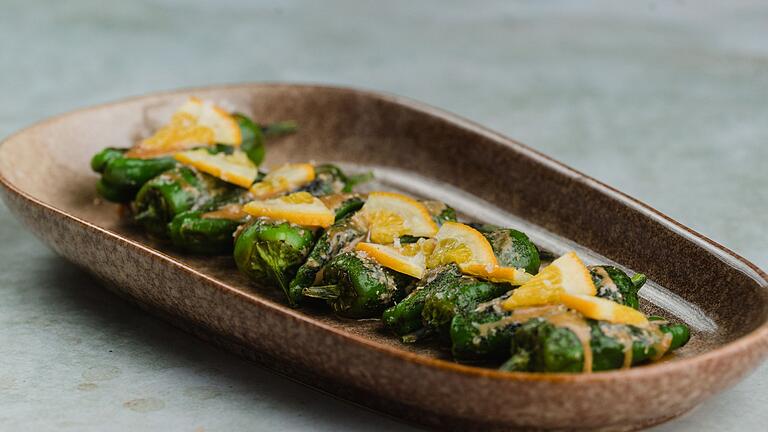 Pimientos de Padrón von Marcel Hertrampf - Die in wenig Olivenöl gebratenen Pimientos richtet Marcel Hertrampf einzeln an mit Dulce de Leche, eingelegten Orangen, lange gereiftem Cheddar und gerösteten Knoblauch-Chips. Pimientos de Padrón von Marcel Hertrampf - Die in wenig Olivenöl gebratenen Pimientos richtet Marcel Hertrampf einzeln an mit Dulce de Leche, eingelegten Orangen, lange gereiftem Cheddar und gerösteten Knoblauch-Chips.