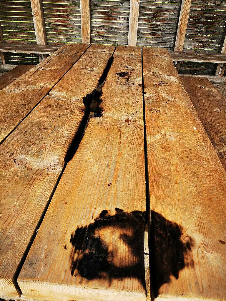 Die runden Brandflecken auf dem Holztisch sind wohl auf das Nutzen von Wasserpfeifen zurückzuführen.